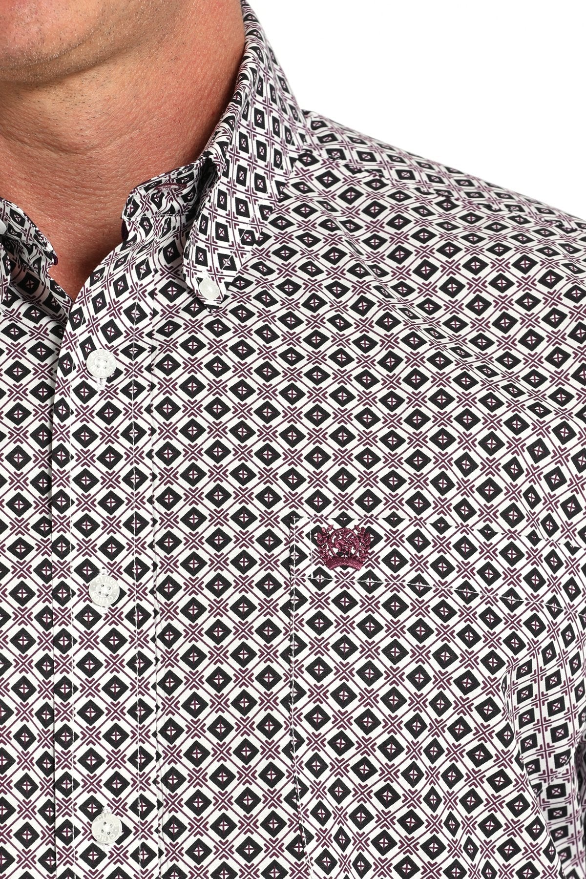 Close-up of a man wearing a long sleeve button-down with a geometric pattern