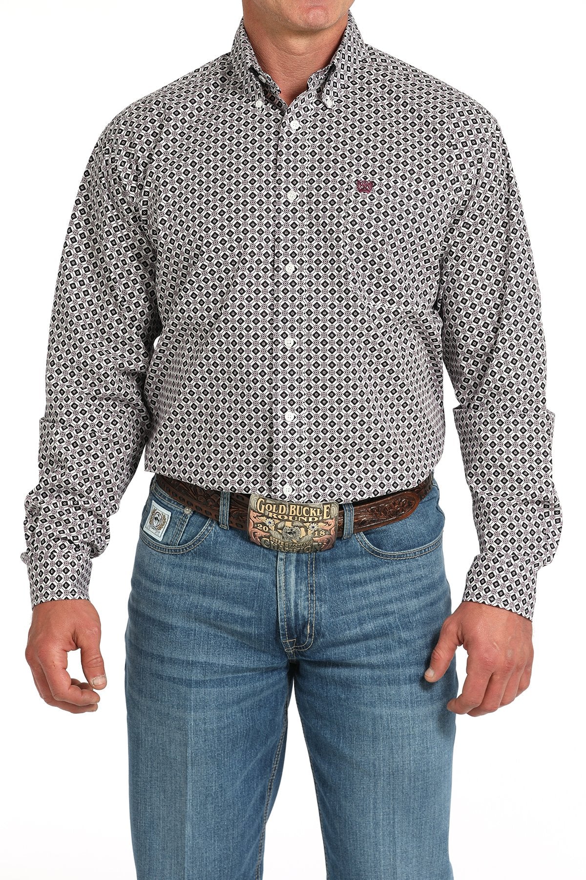 Man wearing a long sleeve button-down with a geometric pattern, paired with jeans and a belt