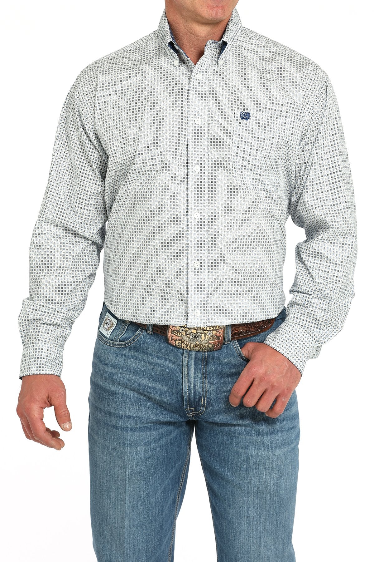 Front view of a man wearing a white long-sleeve button-down shirt with a blue geometric print pattern, paired with blue jeans and a western belt buckle displayed on a white background.