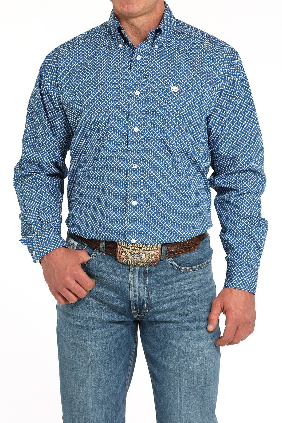 Man wearing a blue patterned button-down shirt tucked into light blue jeans with a western belt buckle displayed on a white background.