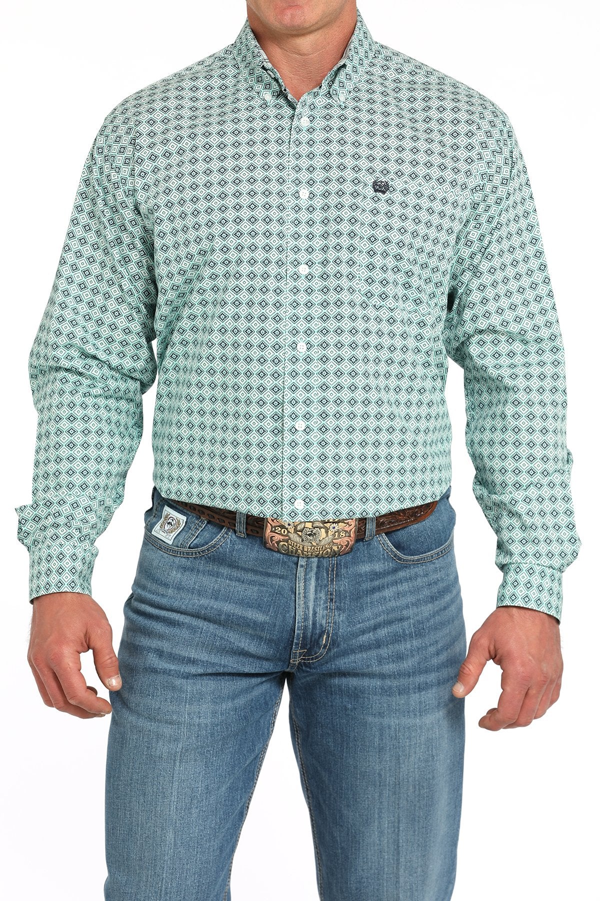 Front view of a man wearing a turquoise long-sleeve button-down shirt with a medallion print pattern, paired with blue jeans and a western belt buckle displayed on a white background.