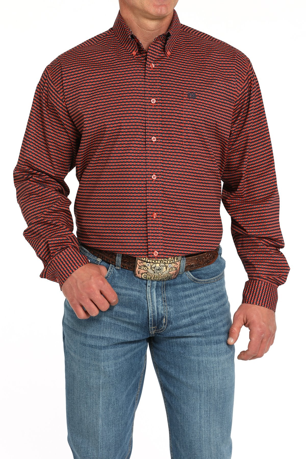 Man wearing a red patterned button-down shirt tucked into blue jeans with a western belt buckle displayed on a white background.