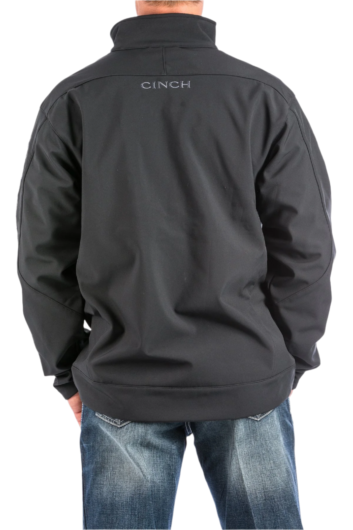 Man wearing a black jacket with the Cinch logo and jeans