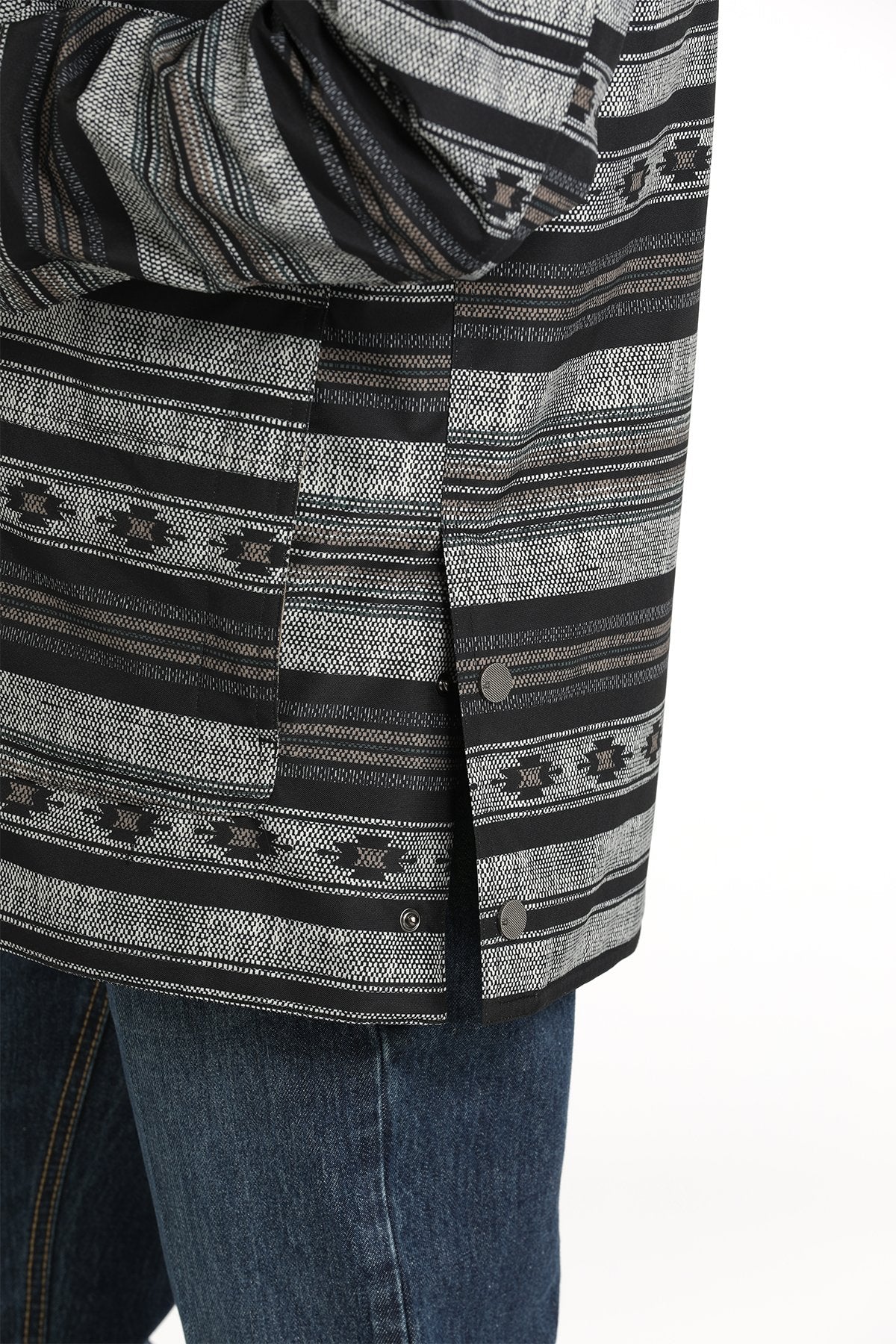 Side-view of a man wearing a black and gray patterned button-up jacket with a hood and blue jeans displayed on a white background.