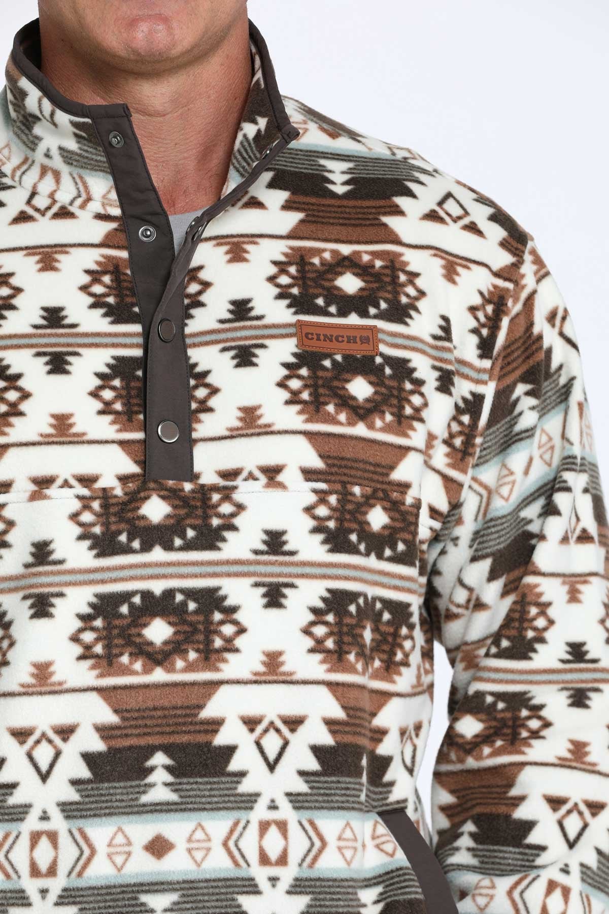 Close-up view of a brown and white Southwestern patterned quarter-zip pullover displayed on a white background