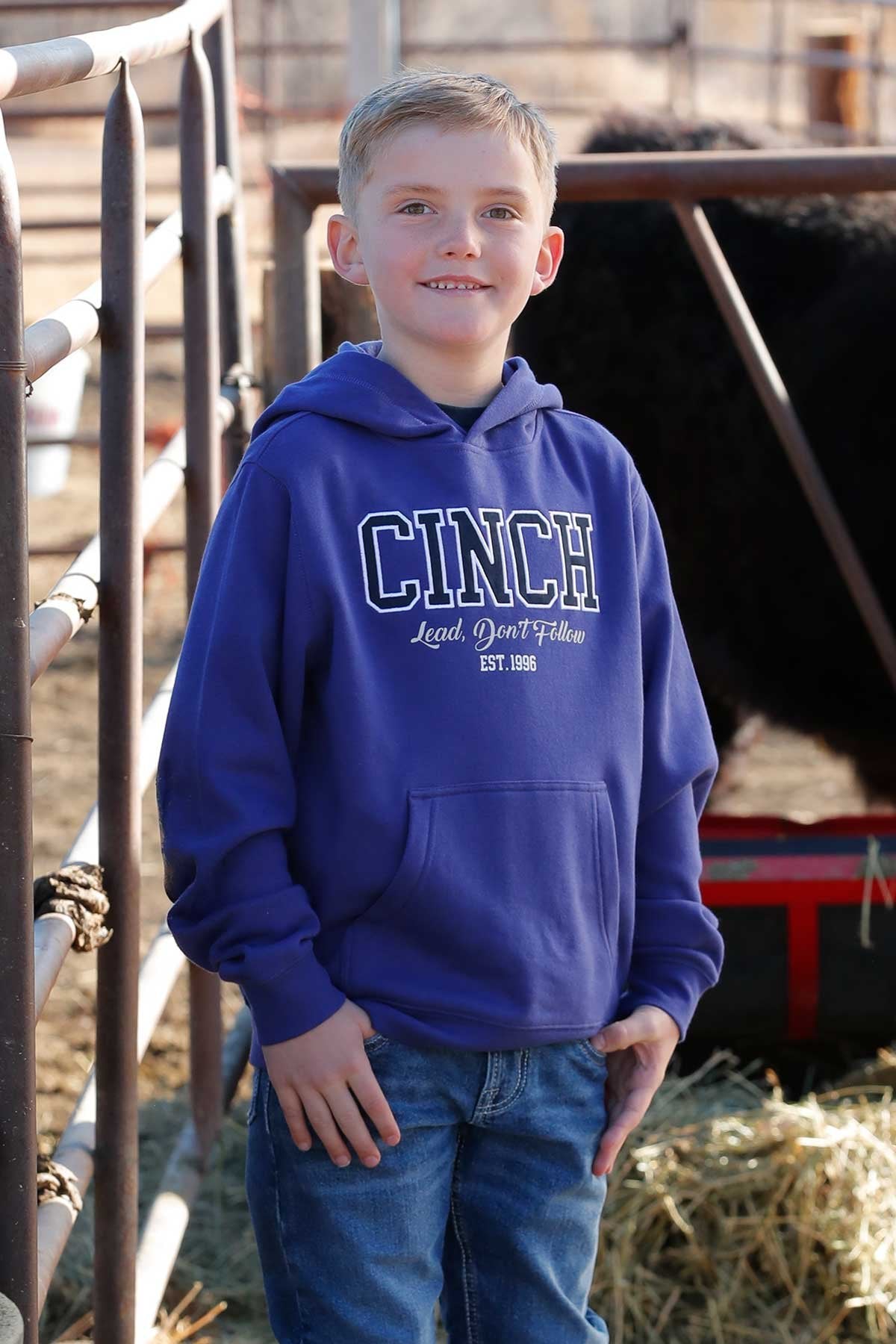 Boy standing outside wearing a hoodie and jeans
