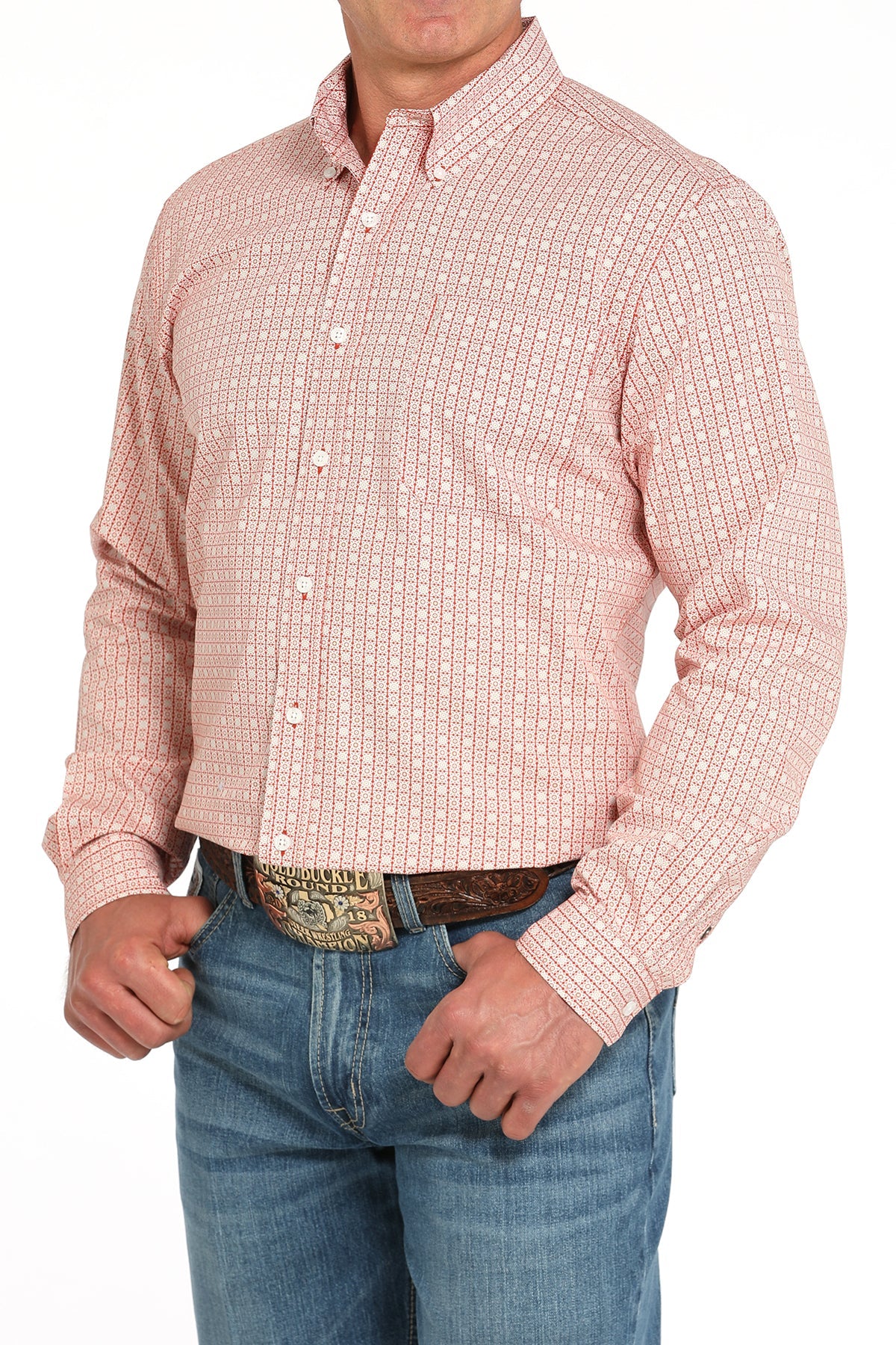 Man wearing a red long sleeve button-down shirt with a geometric print and blue jeans on a white background