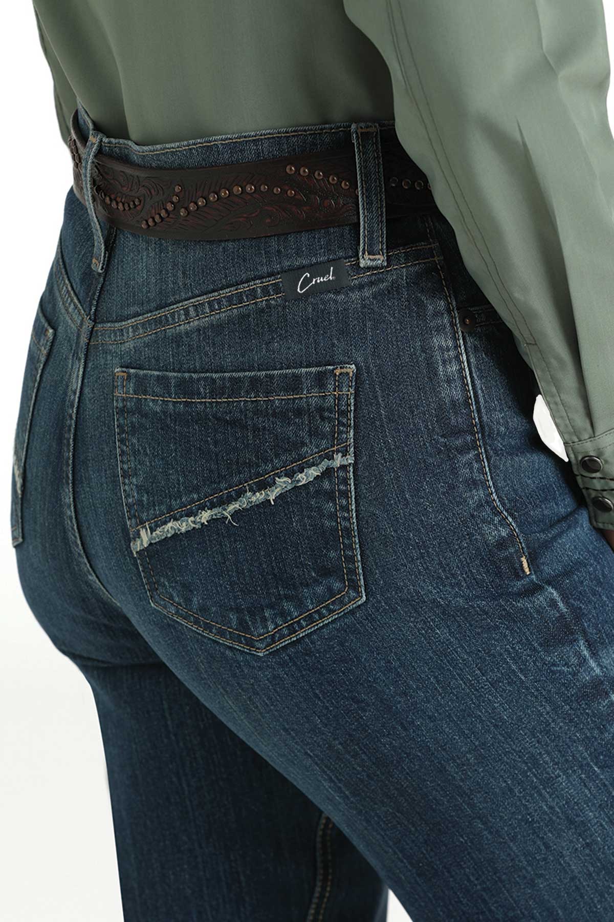 Close-up, back view of a woman wearing dark wash bootcut jeans with a belt and a shirt tucked in 