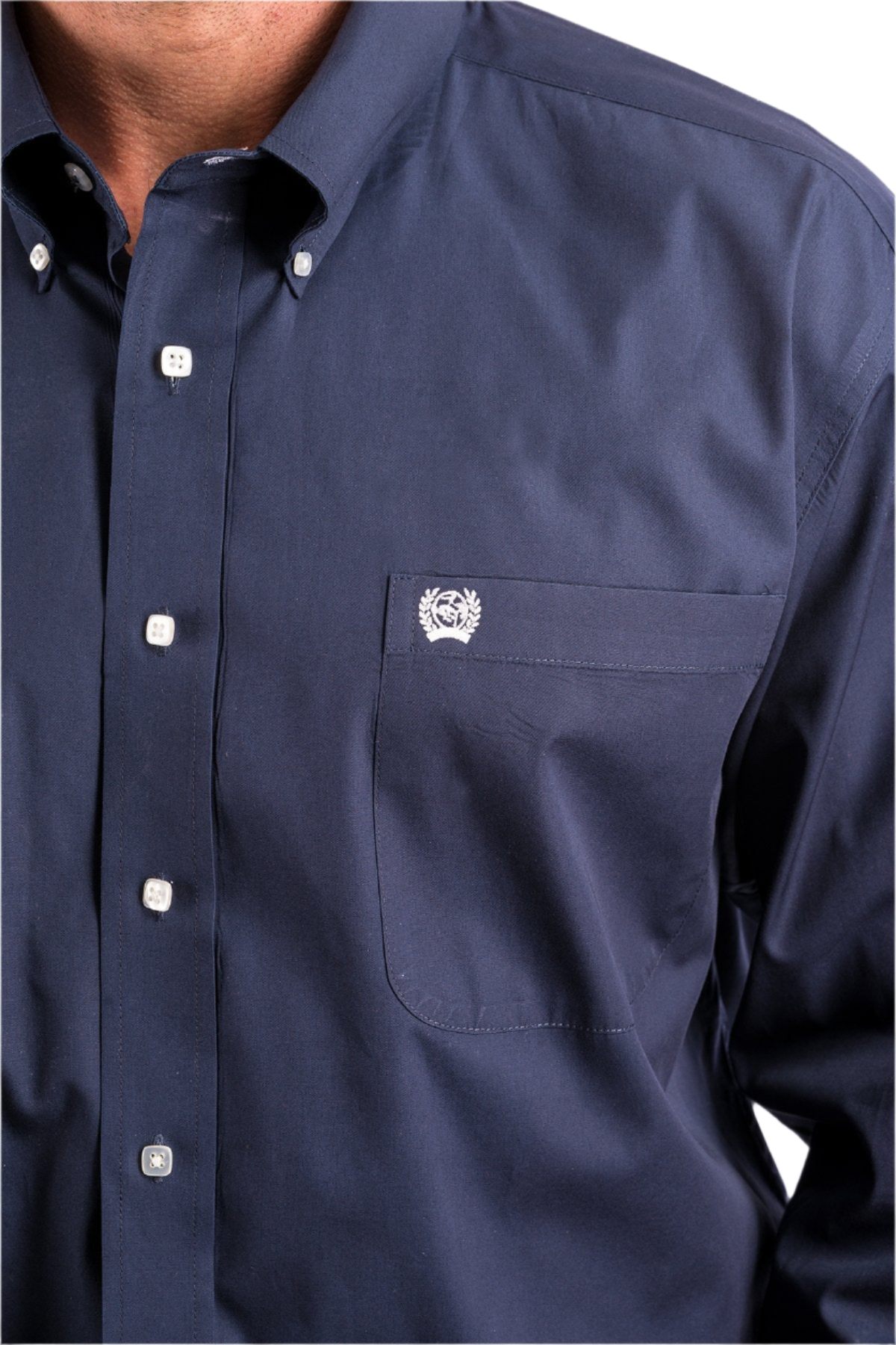 Close-up of a man wearing a navy long sleeve button-down shirt 