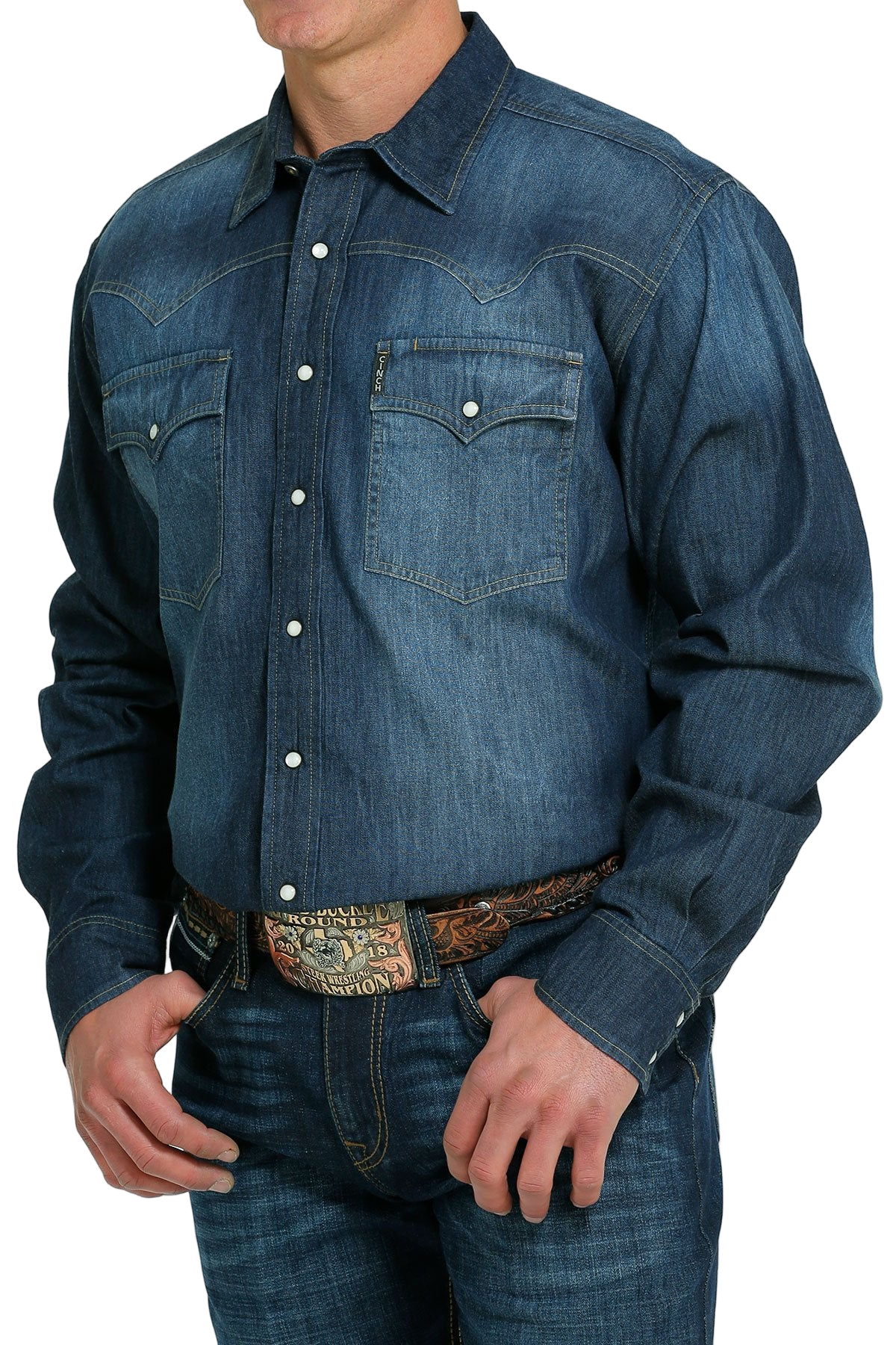 Man wearing a denim button-up shirt with blue jeans on a white background