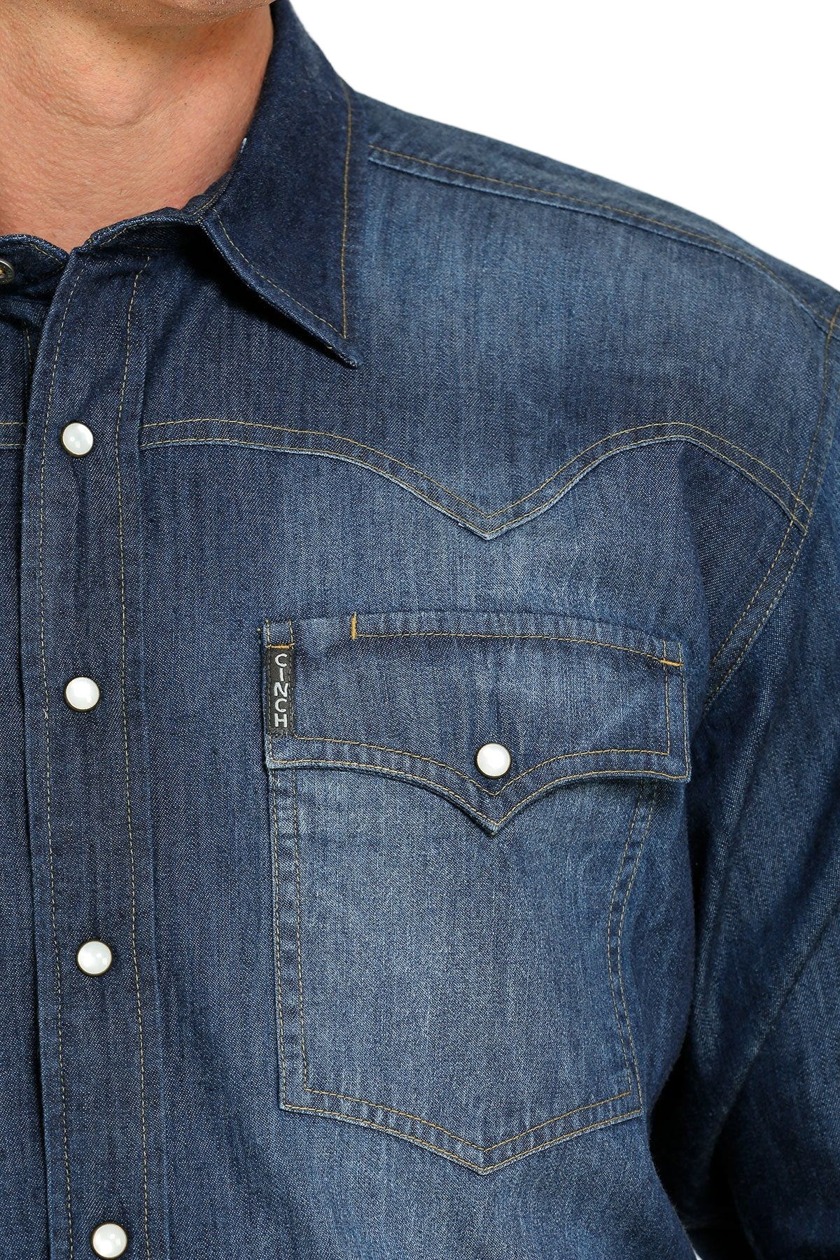 Close-up of a man wearing a denim button-up shirt on a white background