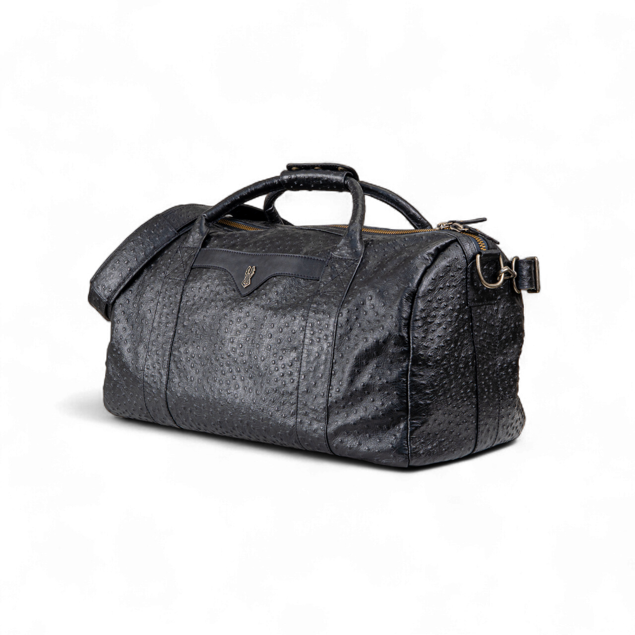 Black ostrich-print duffel bag with dual top handles, a detachable shoulder strap, and a gold zipper. A small metallic emblem is featured on the front center panel