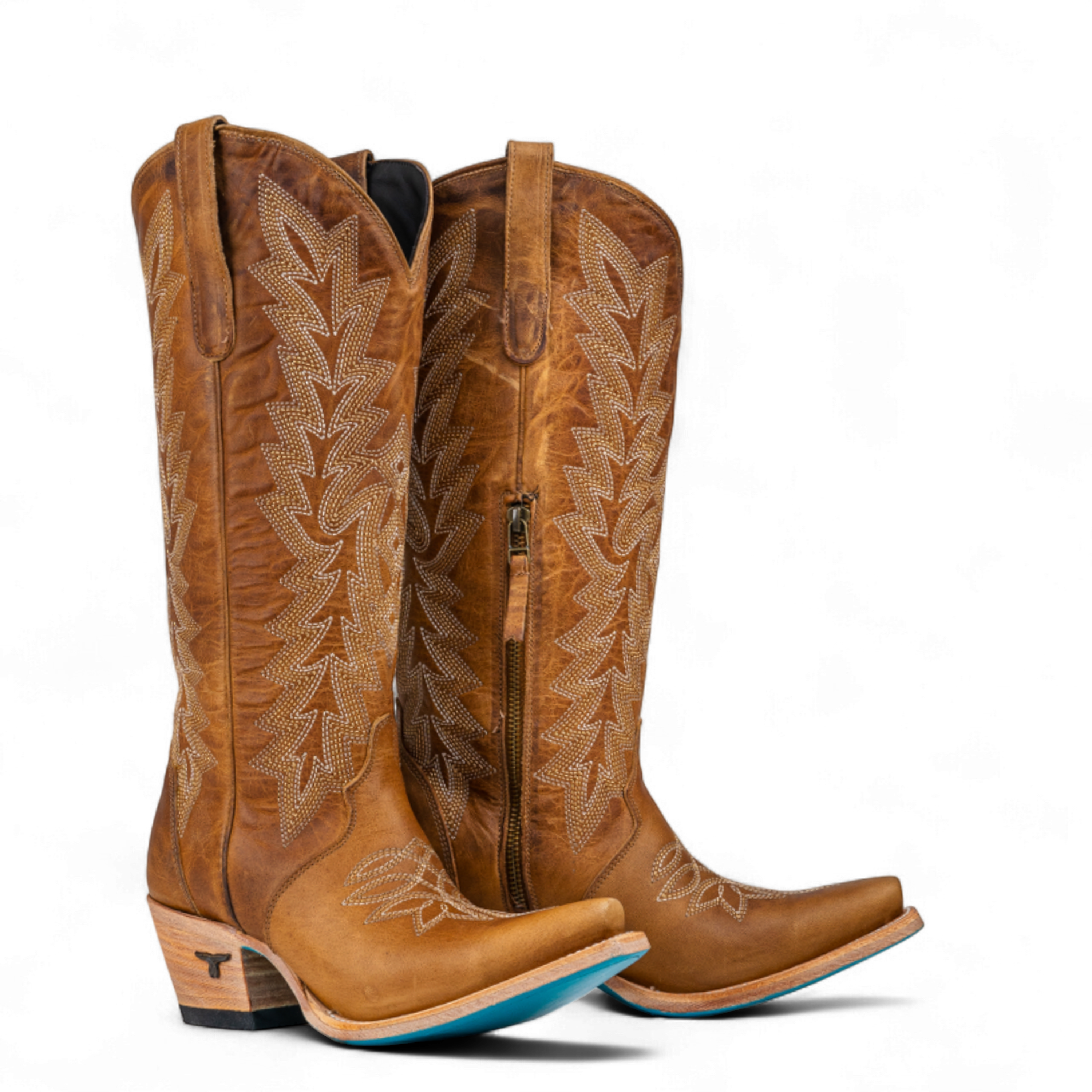 Pair of brown cowboy boots with intricate designs on a white background