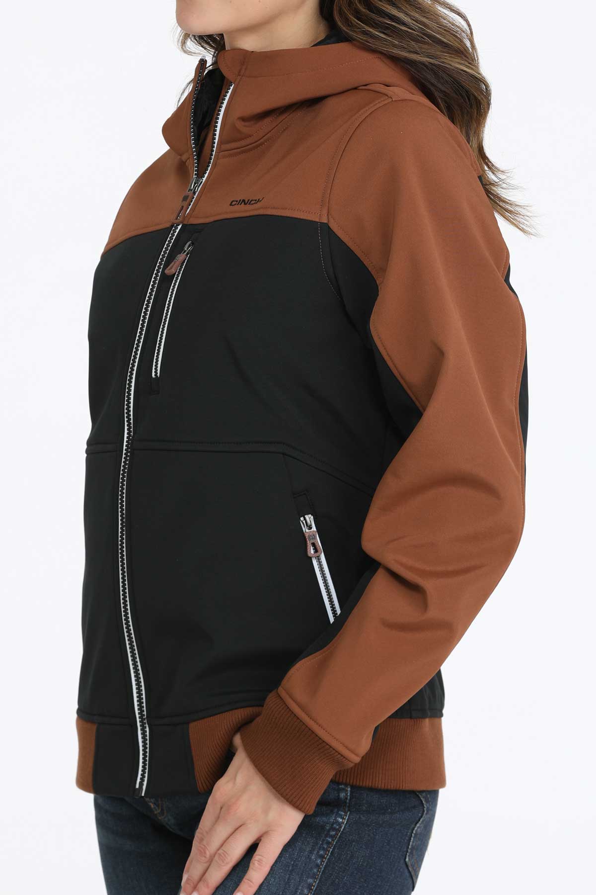 Woman wearing a two-toned black and brown jacket with jeans 