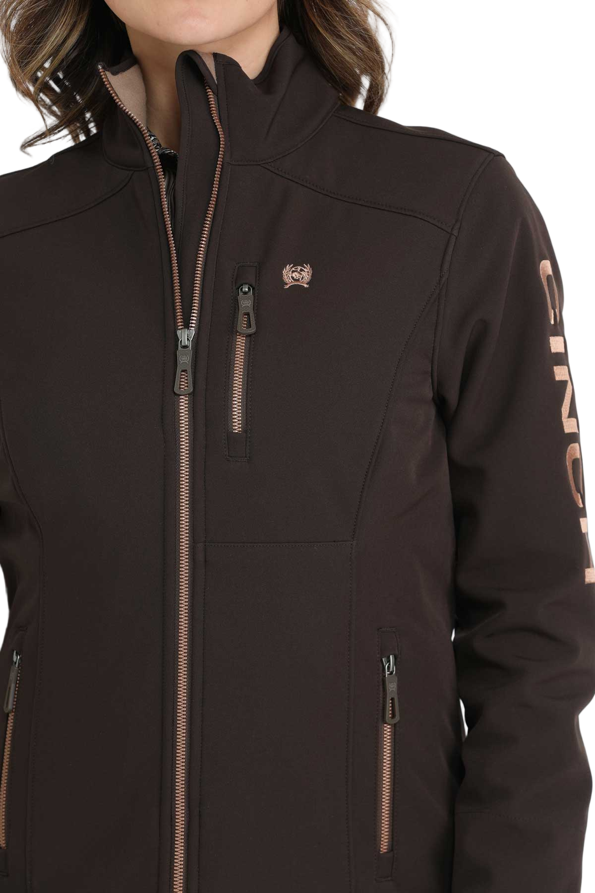 Woman wearing a dark brown CINCH softshell jacket with a front zipper and a chest pocket