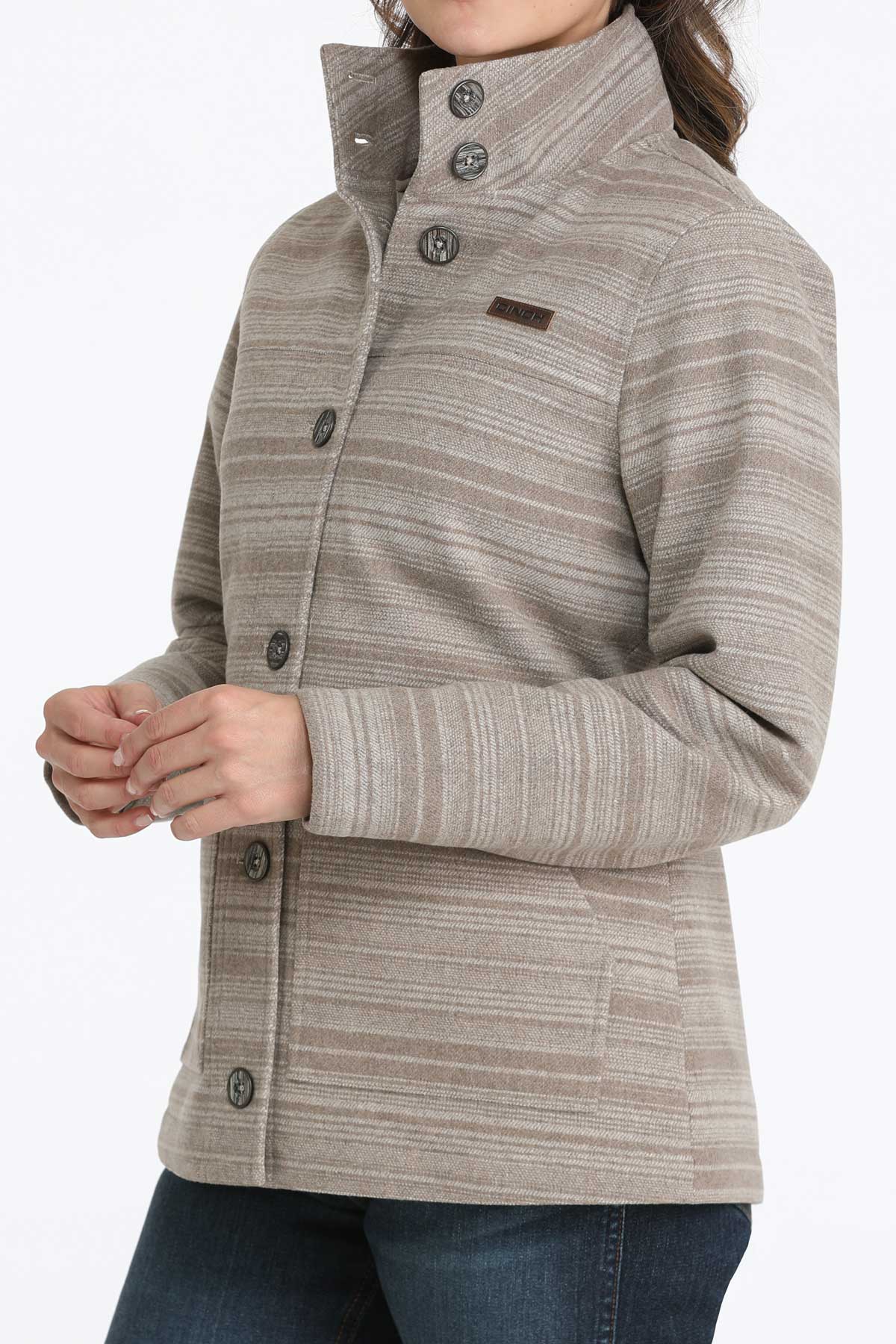 Woman wearing a gray jacket with subtle horizontal stripes and jeans 