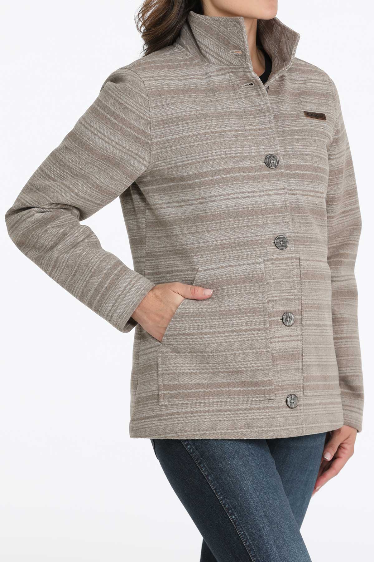 Woman wearing a gray jacket with subtle horizontal stripes and jeans 
