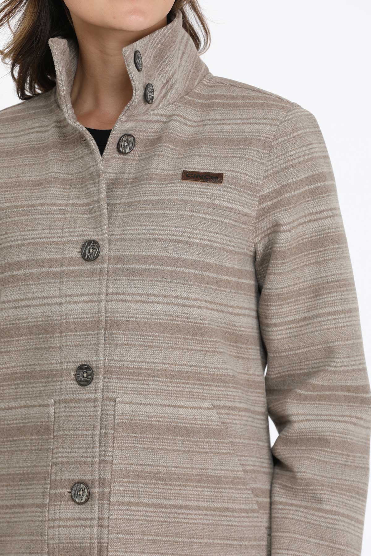 Close-up of a woman wearing a gray jacket with subtle horizontal stripes 