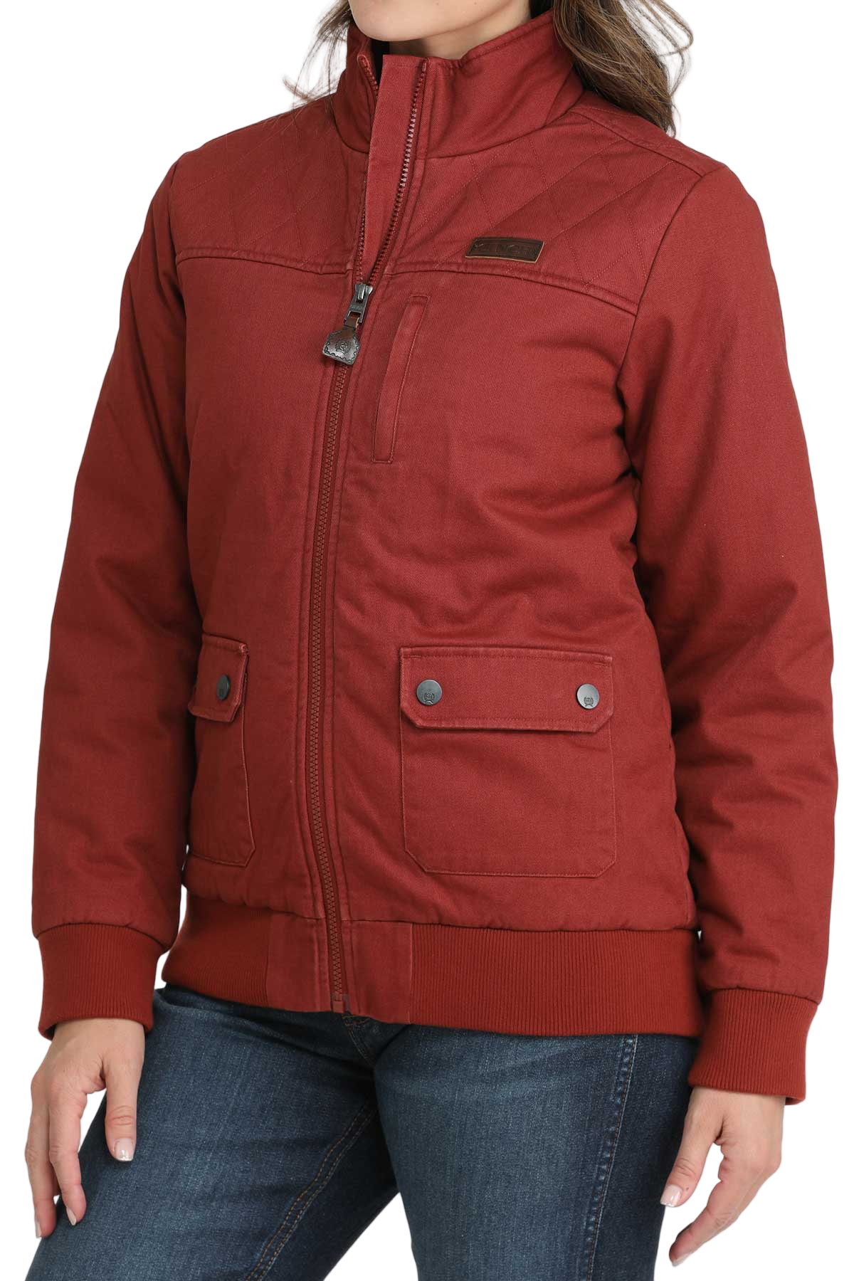 Woman wearing a red zip-up jacket with front flap pockets and dark jeans