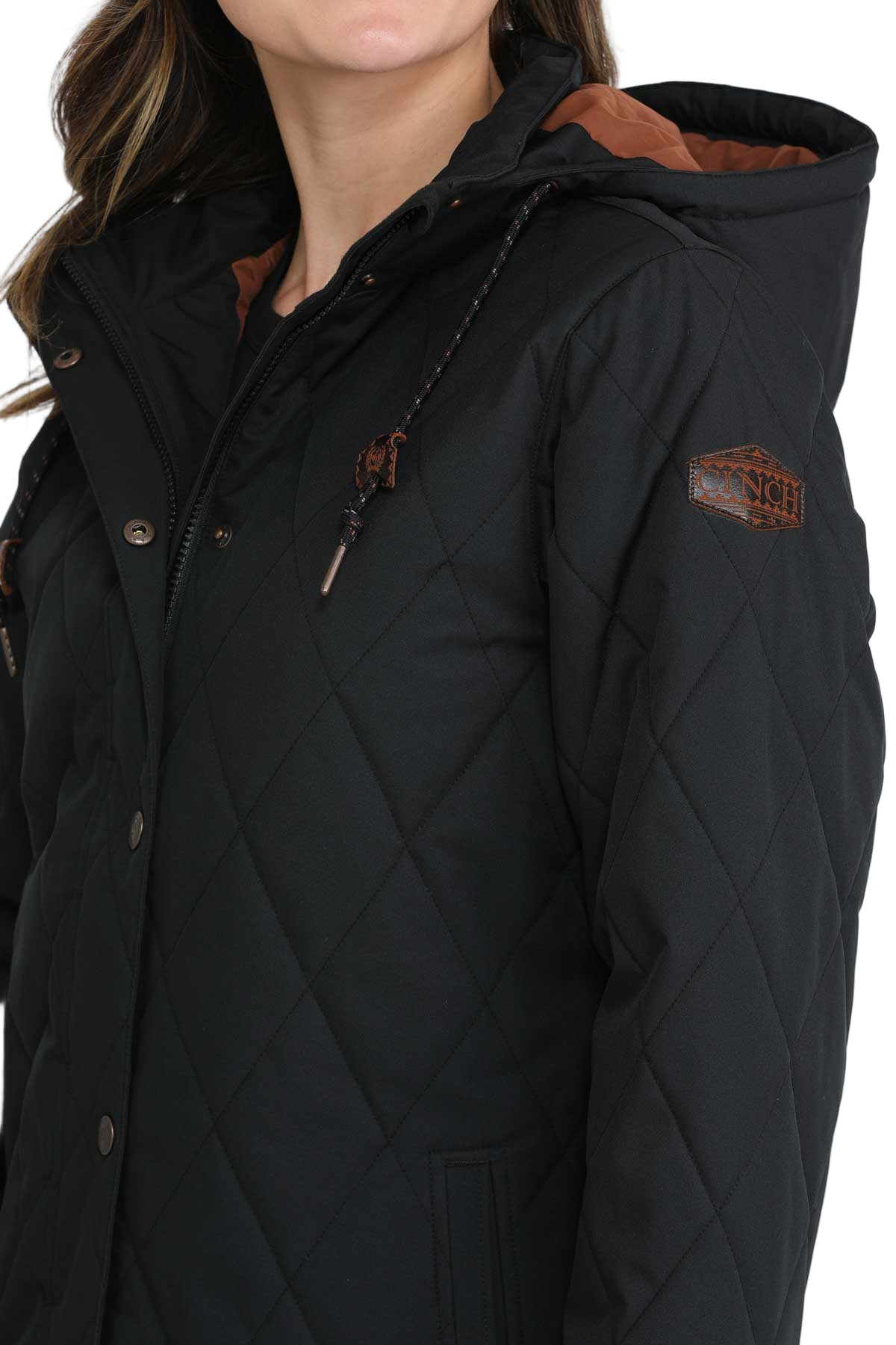 Woman wearing a long black quilted jacket with a hood