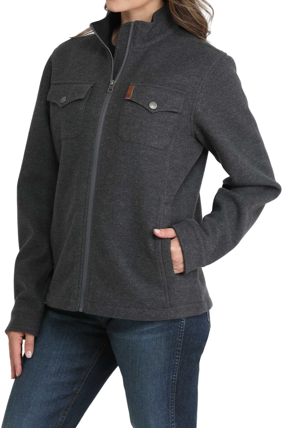 Woman wearing a dark gray zip-up jacket with flap chest pockets and side pockets, paired with blue jeans. The jacket has a high collar and a simple, casual design