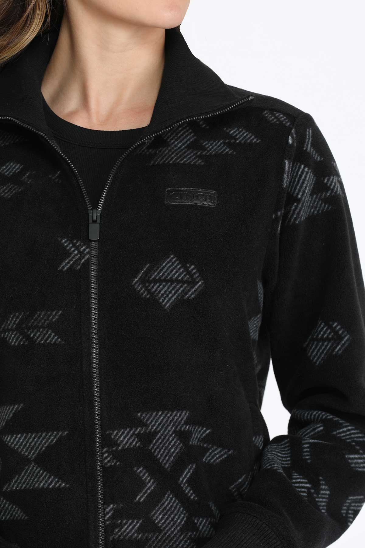 Close-up of a woman wearing a black jacket with a subtle pattern 