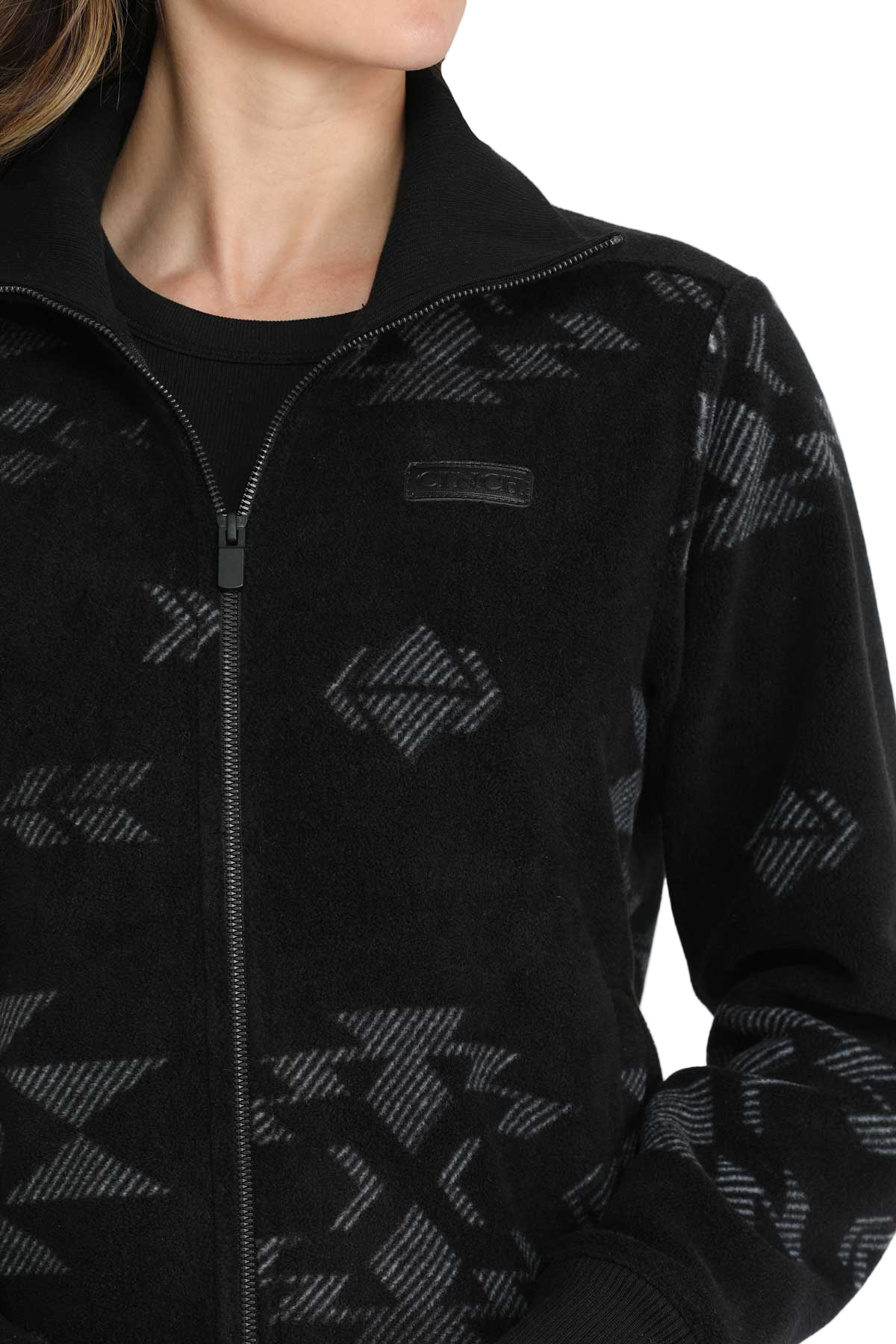 Close-up of a woman wearing a black zip-up jacket with a subtle gray southwest-style pattern