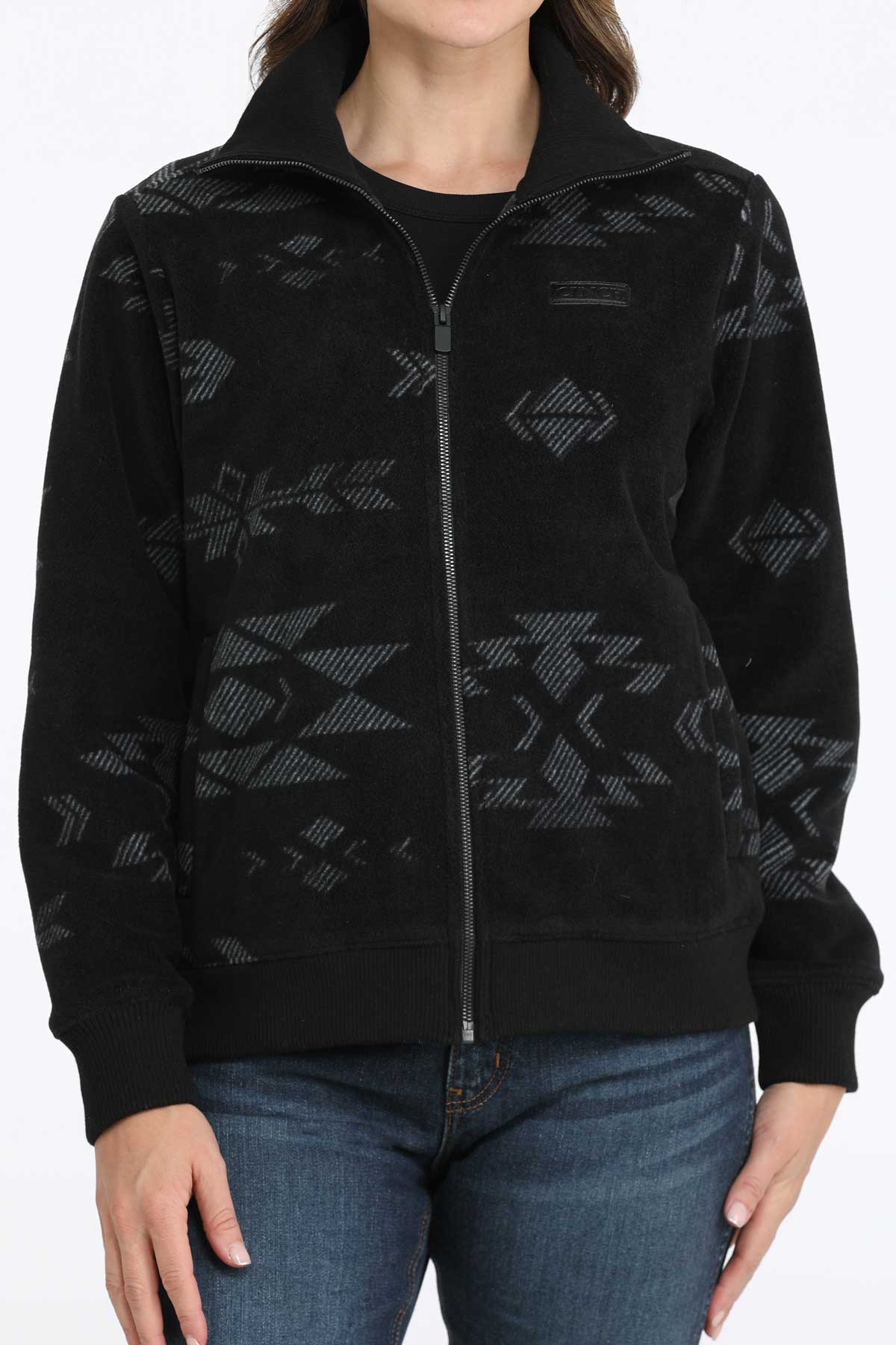Woman wearing a black jacket with a subtle pattern and jeans