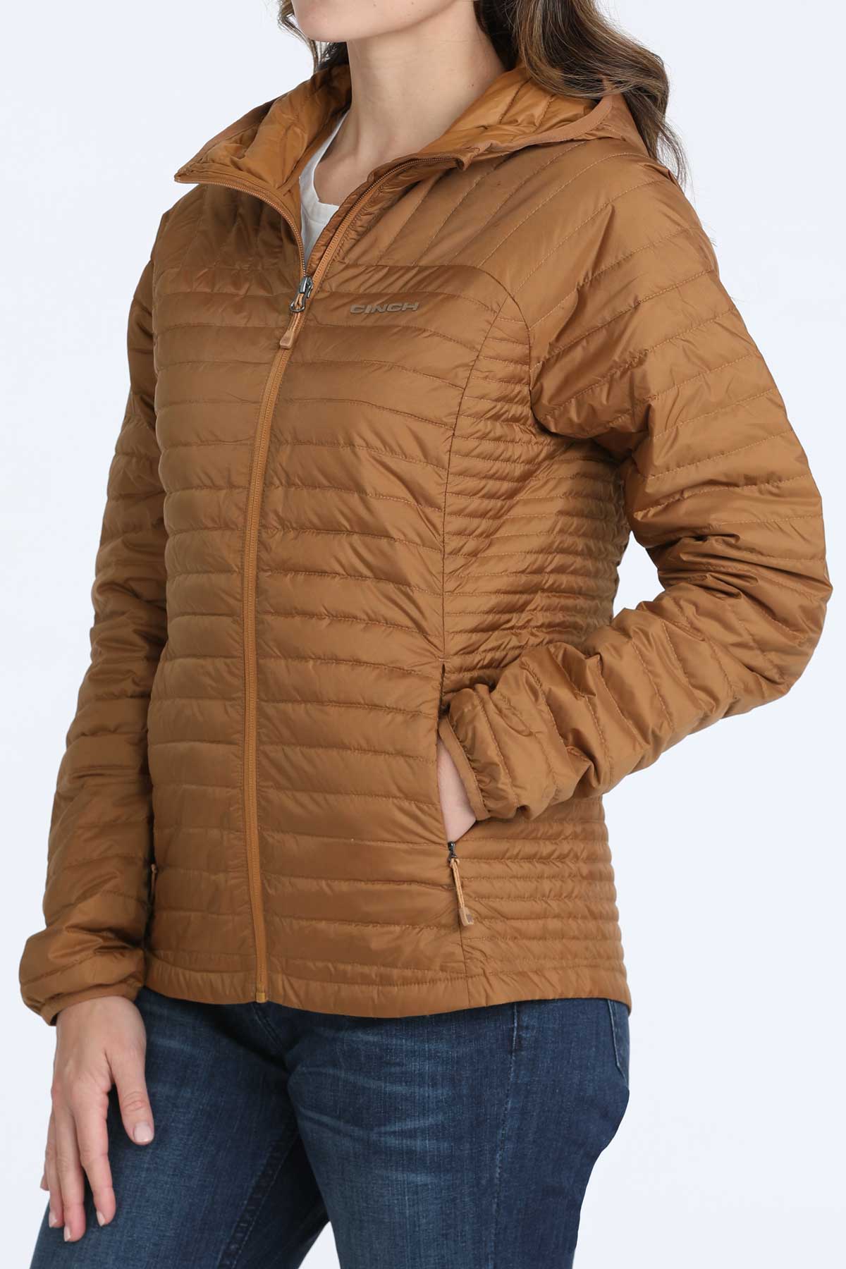 Woman wearing a brown puffer jacket and jeans 