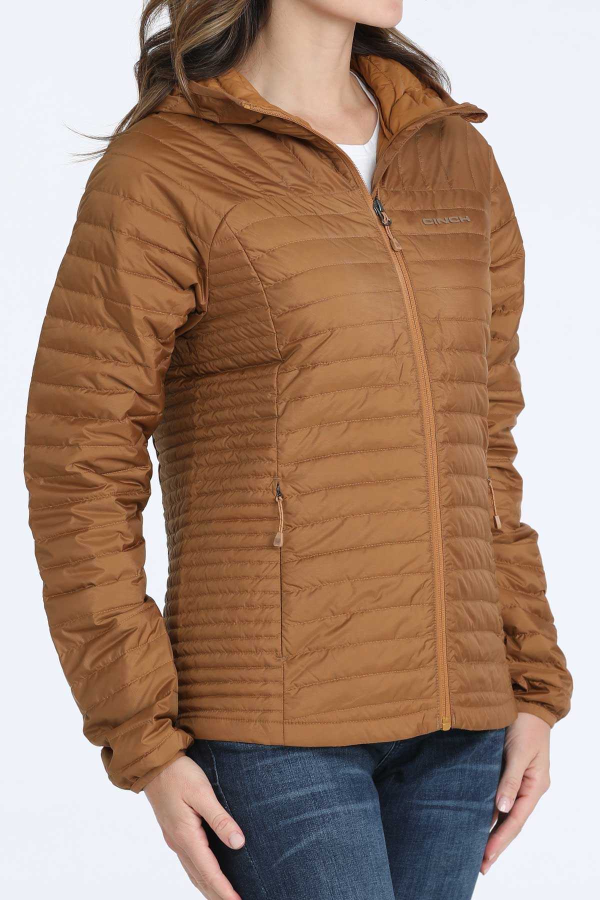 Woman wearing a brown puffer jacket and jeans 
