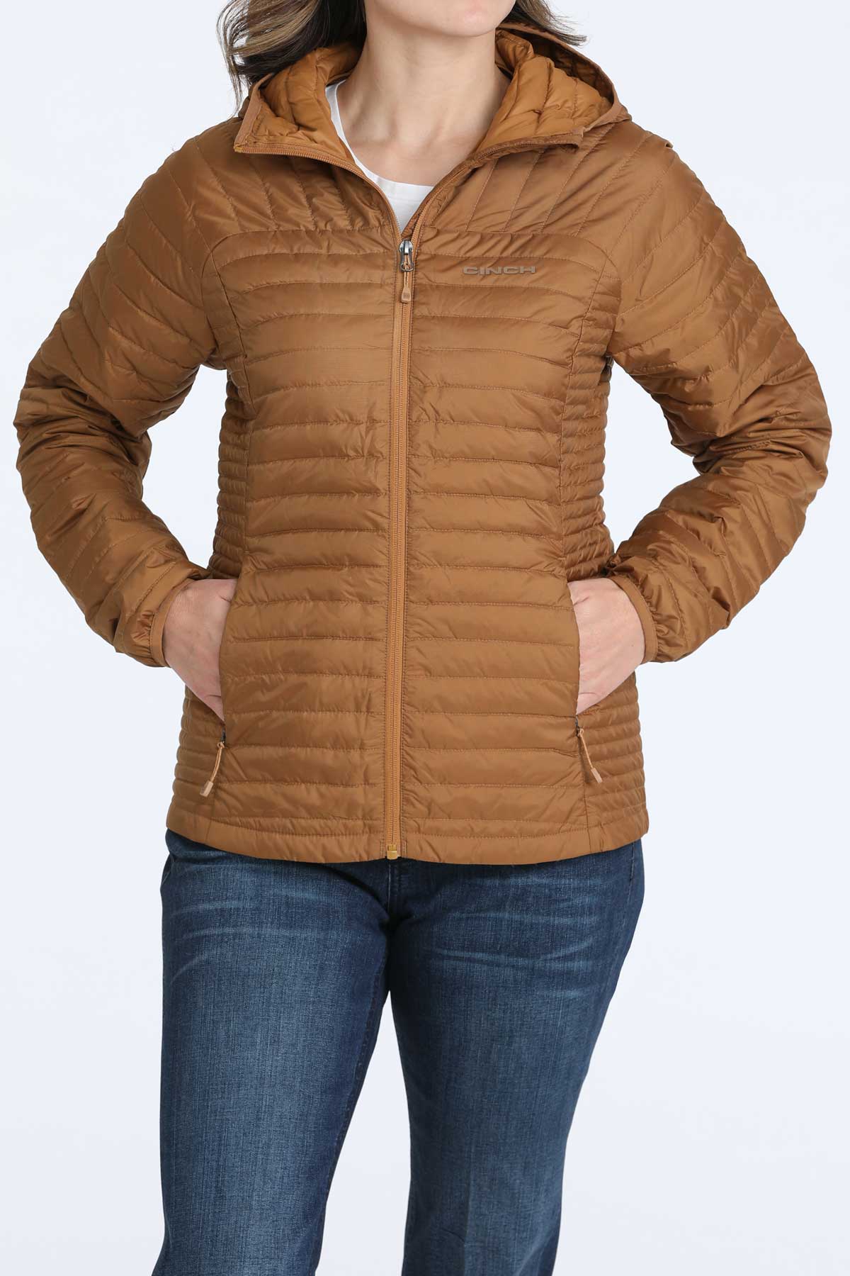 Woman wearing a brown puffer jacket and jeans 