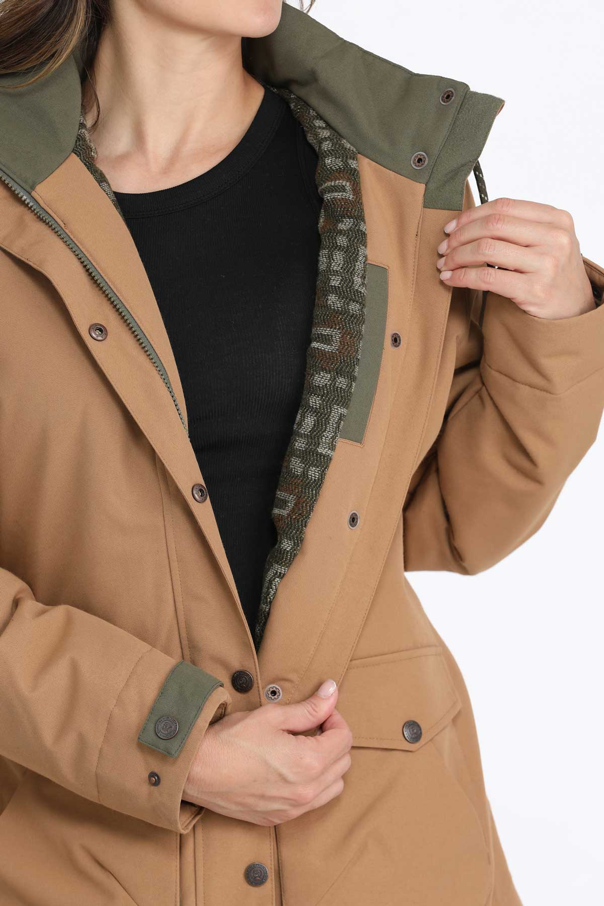 Close-up of a woman wearing a brown jacket with green accents and a patterned fleece interior