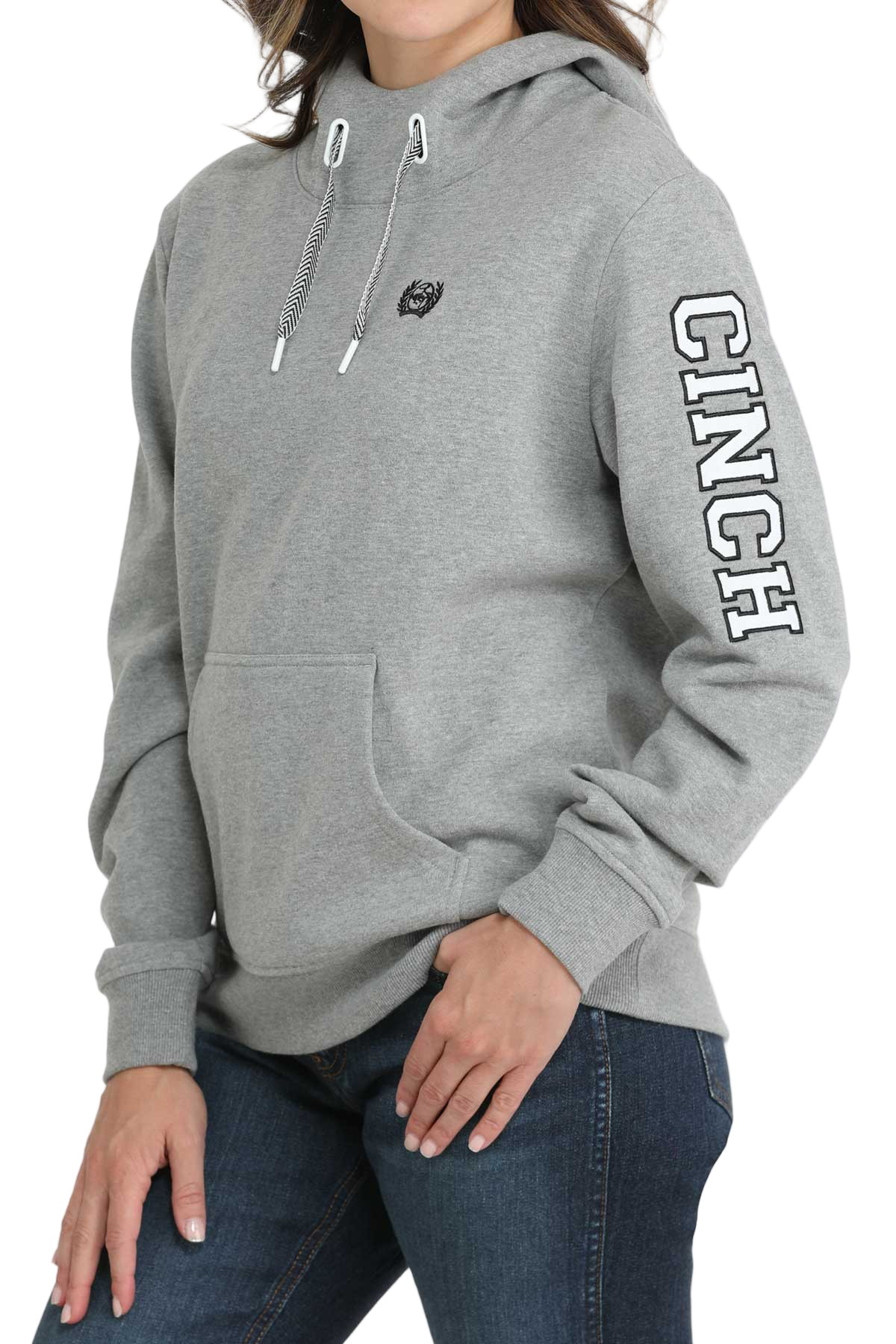 Woman wearing a light-gray hooded sweatshirt with a front pouch pocket and ribbed cuffs, paired with dark-wash jeans