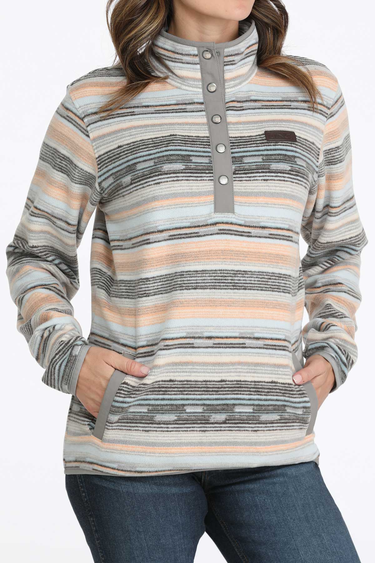 Woman wearing a multi-colored fleece pullover and jeans 