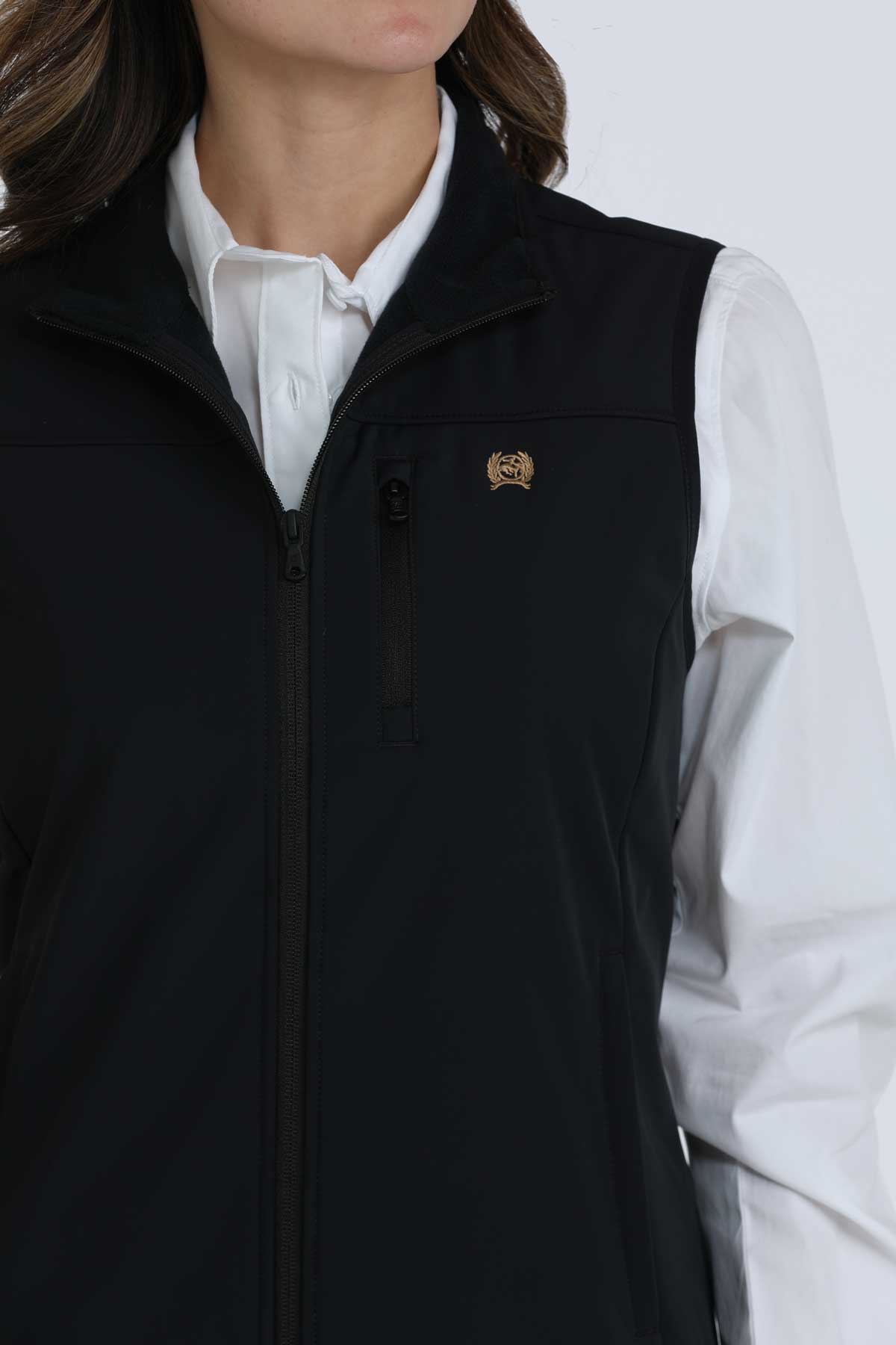 Close-up of a woman wearing a black vest with a white undershirt 