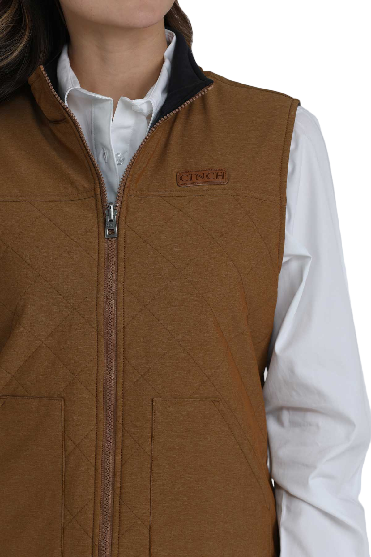 Close-up of a woman wearing a brown quilted vest over a white button-up shirt