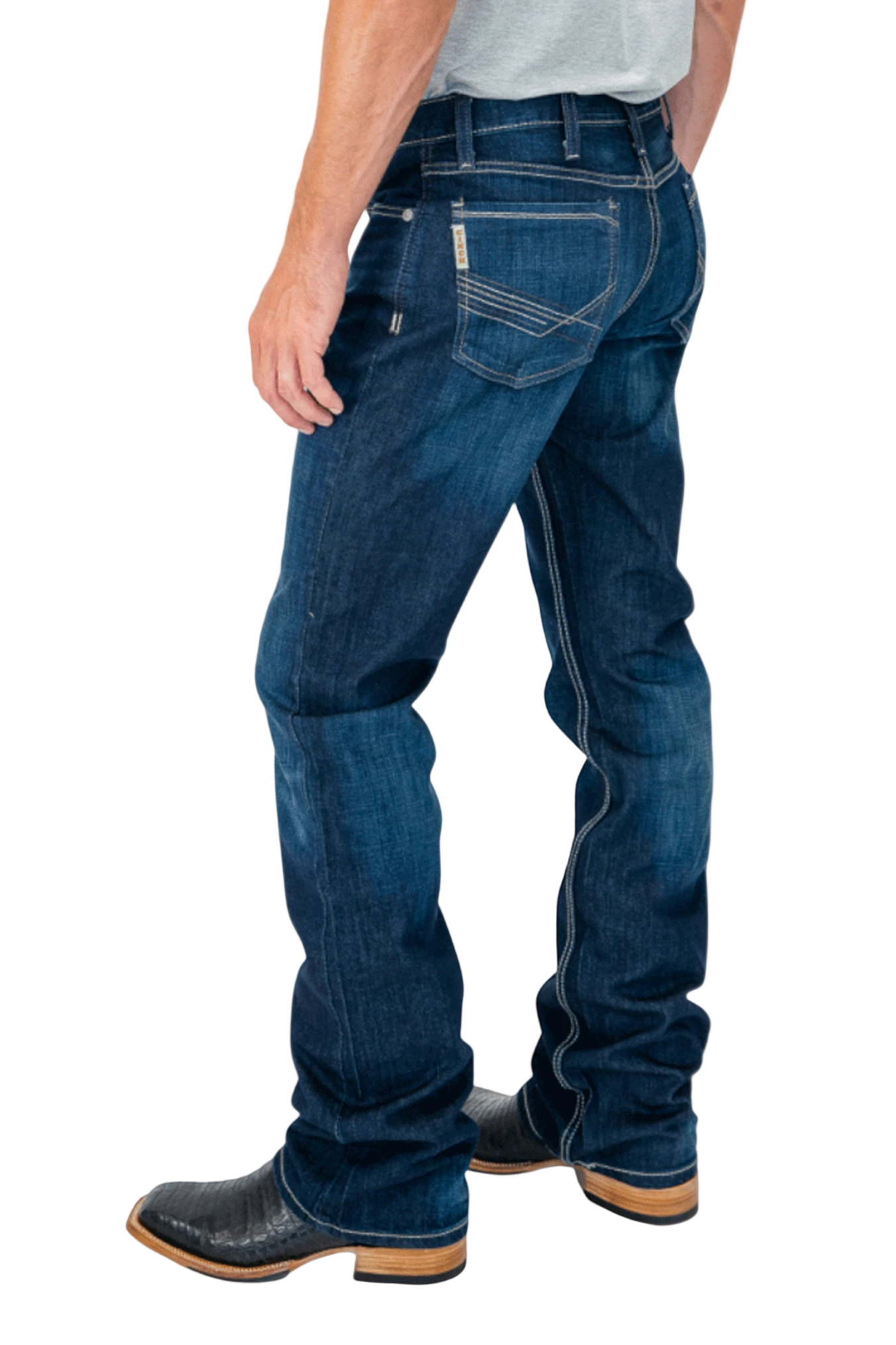 Person wearing blue jeans and black boots on a white background