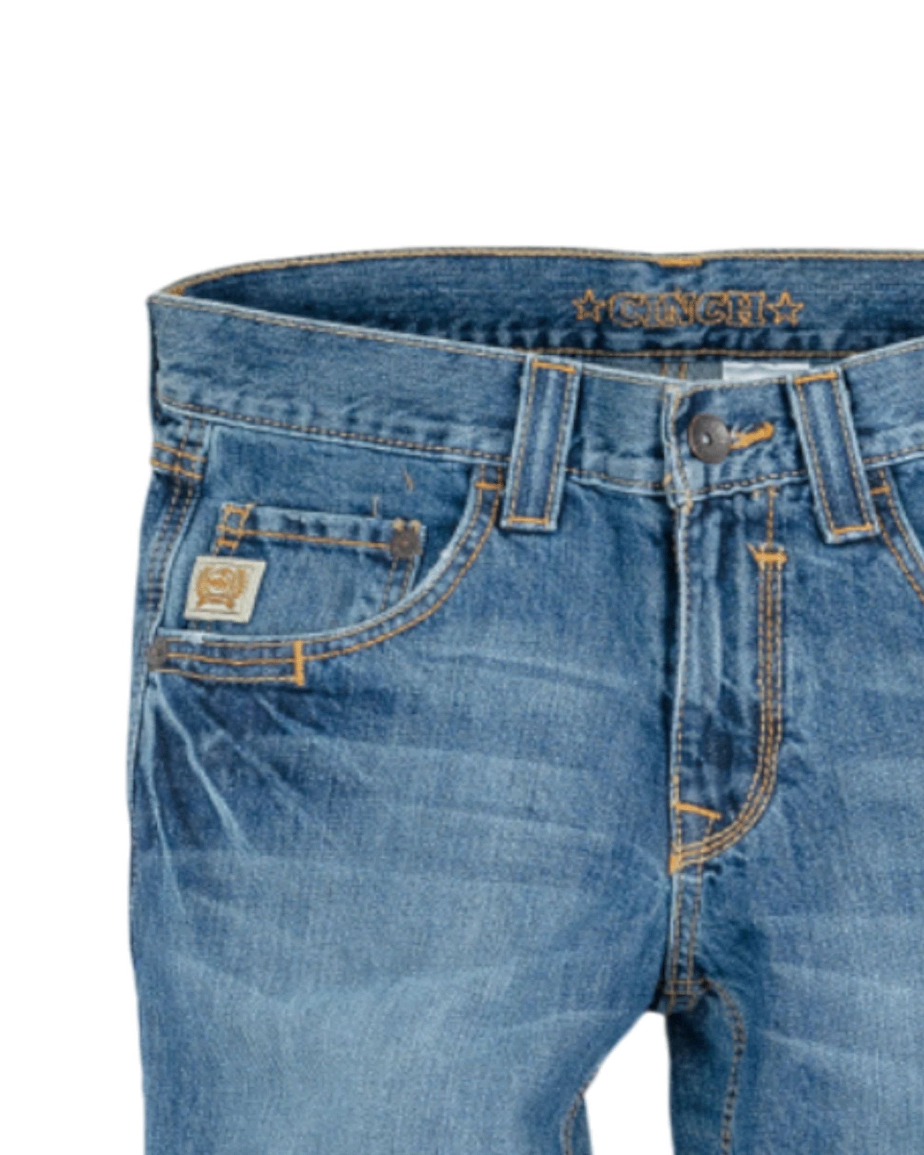 Close-up of the front of blue denim jeans with light fading, featuring a coin pocket with a small embroidered patch, belt loops, and a button closure with a zipper fly. The waistband has 'CINCH' stitched in gold thread