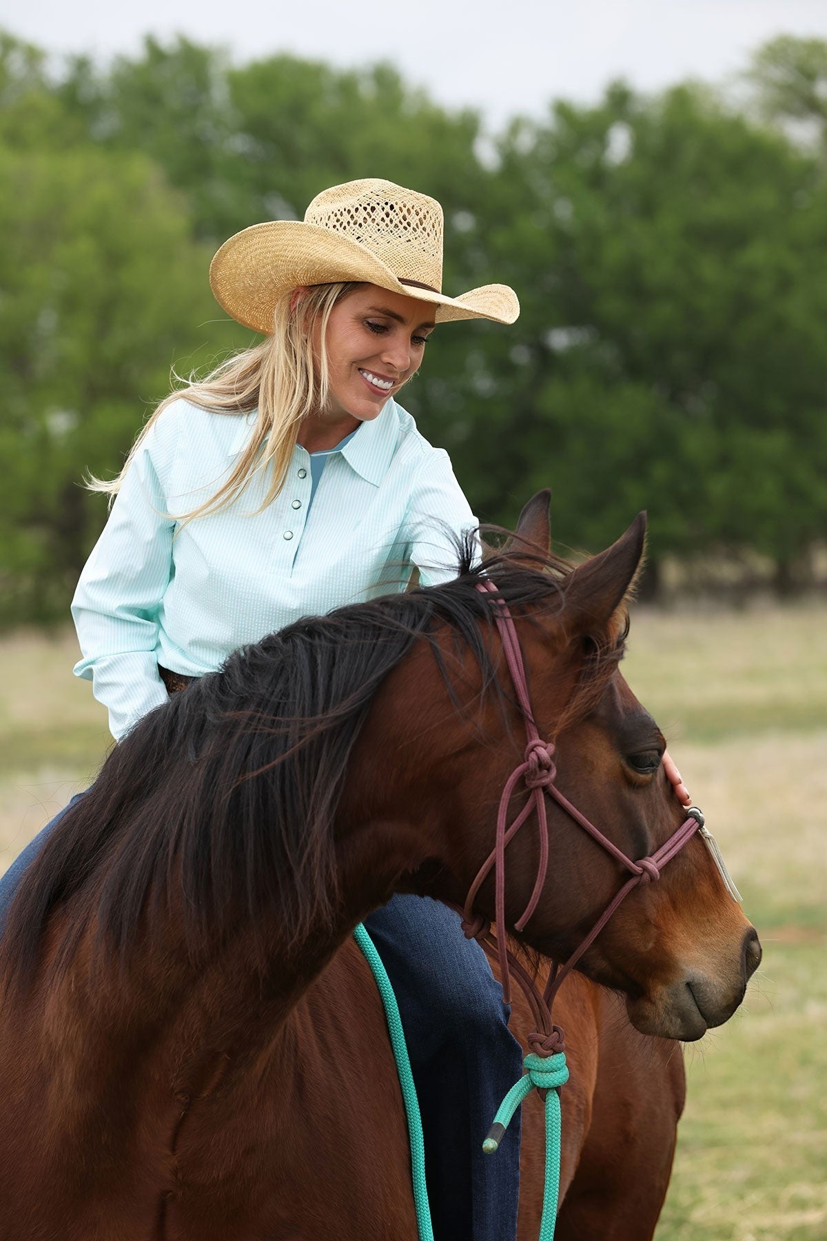 Go West Supply light turquoise striped long sleeve poly-spandex shirt with pearl buttons and embroidered logo.