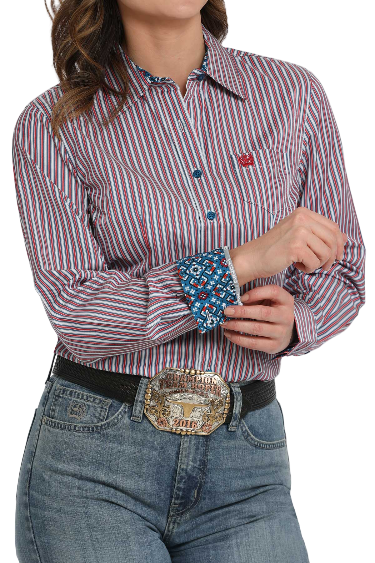 Woman wearing a purple striped long-sleeve button-down shirt with contrasting cuffs, paired with jeans and a large western belt buckle