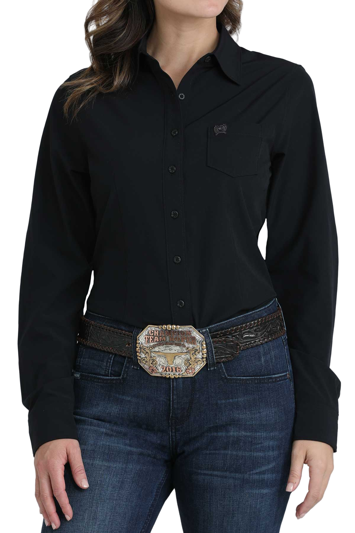 Woman wearing a black long-sleeve button-down shirt, paired with jeans and a large western belt buckle