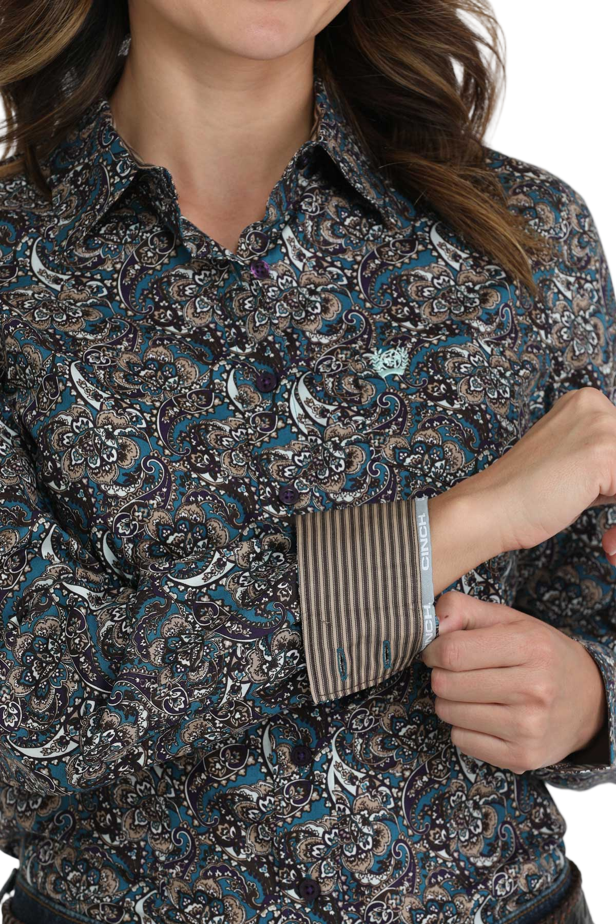 Close-up of a woman wearing a patterned button-down shirt with striped contrast cuffs