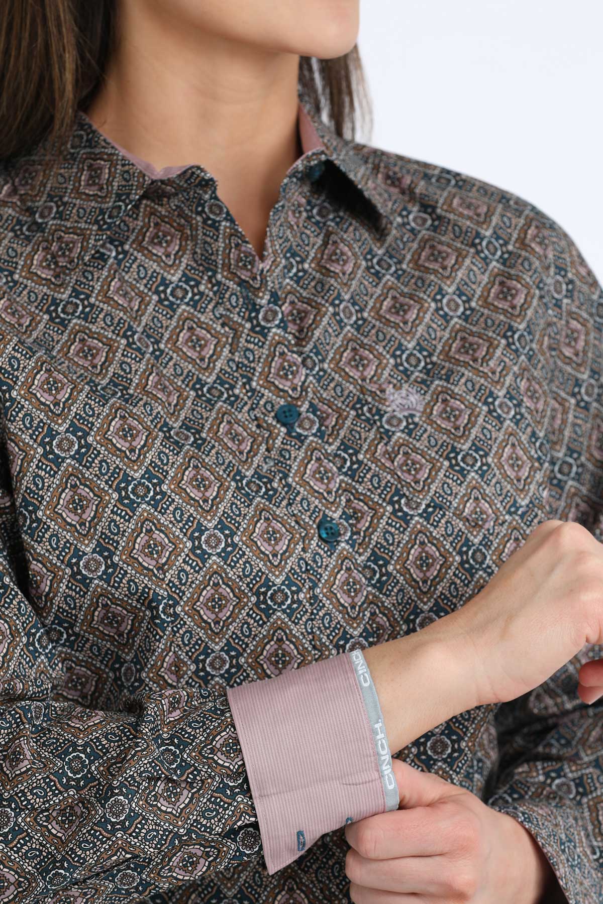 Close-up of a person wearing a patterned shirt with rolled-up sleeve.