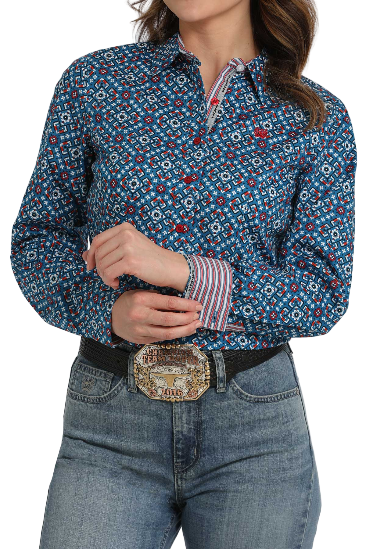 Woman wearing a blue patterned long-sleeve shirt paired with light-wash jeans and a belt with a decorative buckle