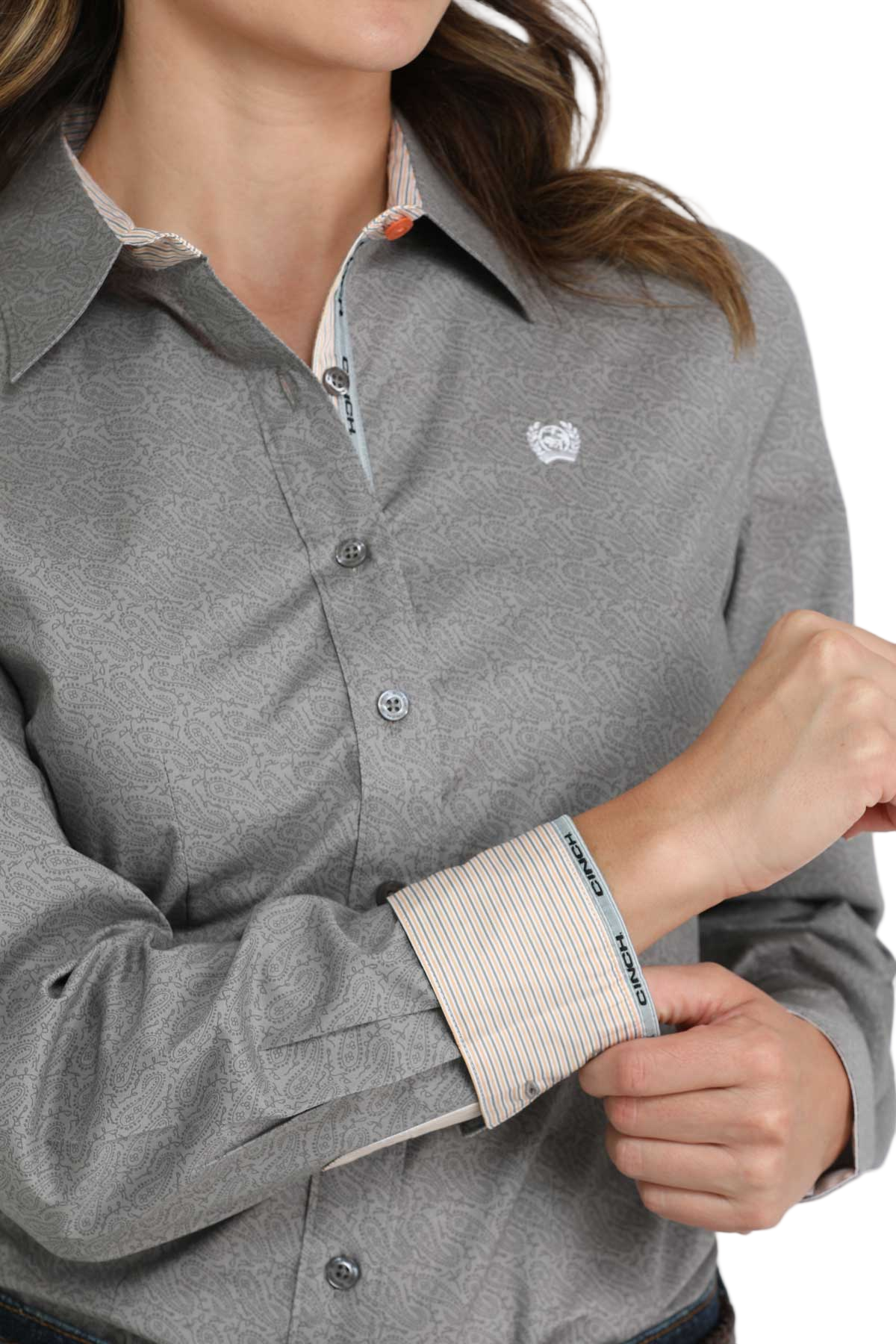 Close-up of a woman wearing a gray long-sleeve button-down shirt with contrasting cuffs