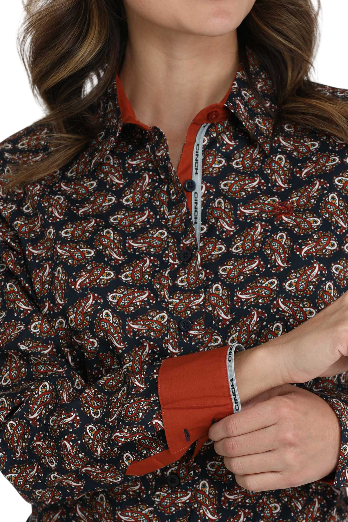 Close-up of a woman wearing a dark patterned button-down shirt with solid red contrast cuffs and collar