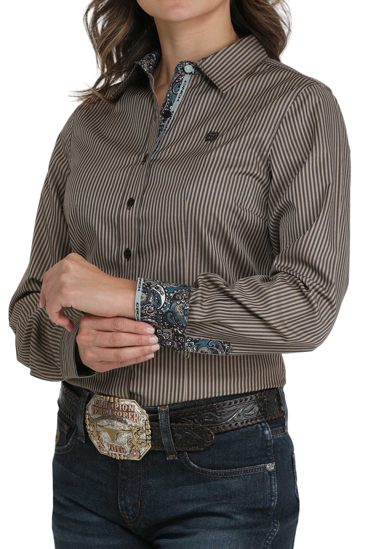 Woman wearing a brown striped button-down shirt with a contrasting patterned trim on the collar and cuffs, paired with jeans