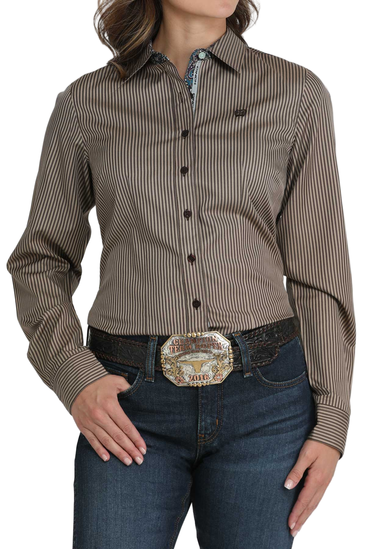 Woman wearing a brown striped button-down shirt with a contrasting patterned trim on the collar and cuffs, paired with jeans
