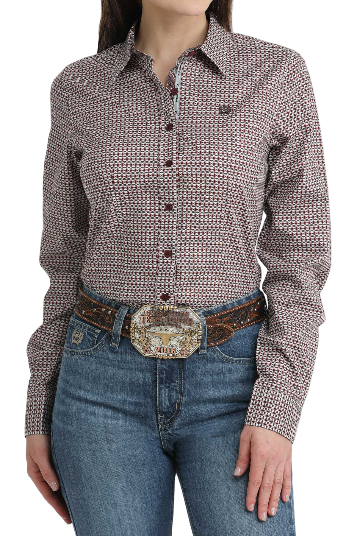 Person wearing a patterned long-sleeve shirt and jeans with a belt and large buckle.