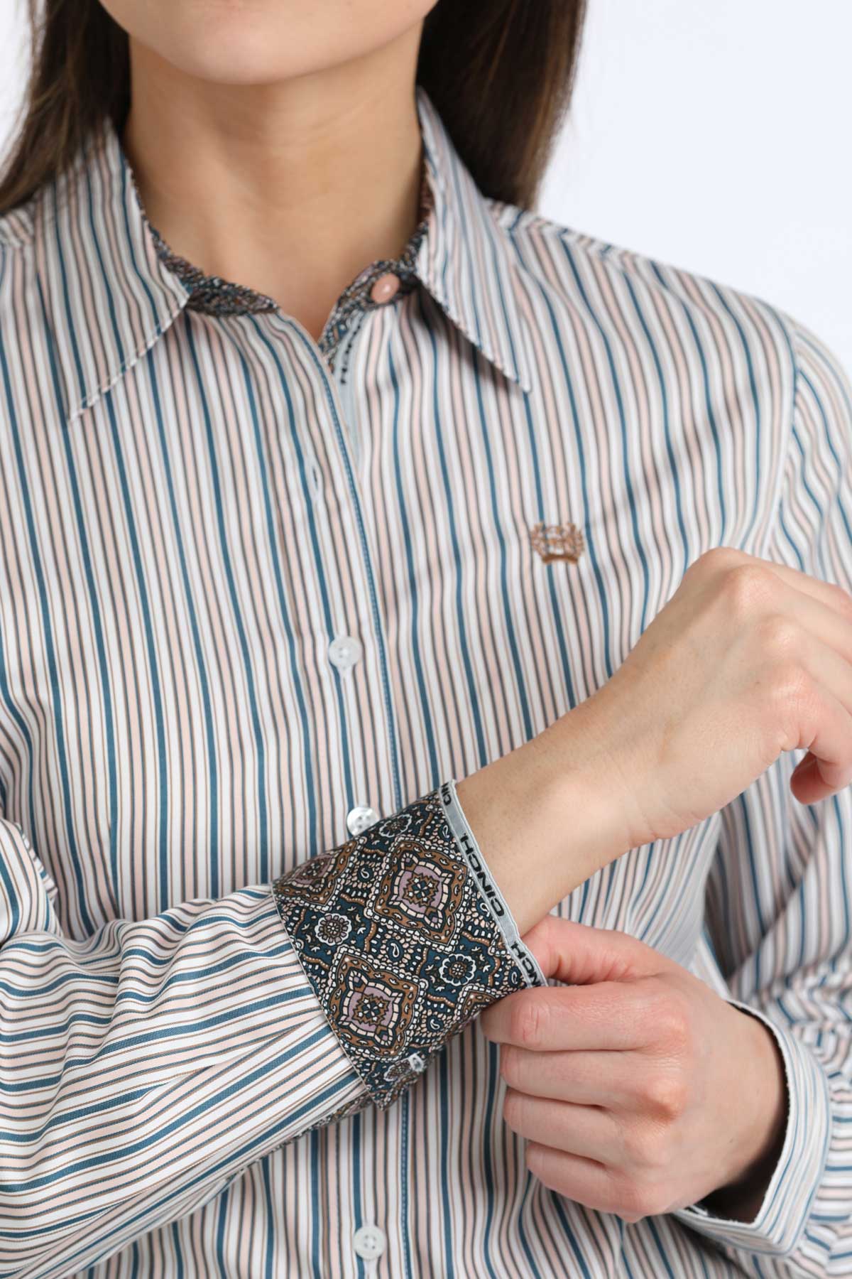 Close-up of a person wearing a striped shirt with patterned cuffs.